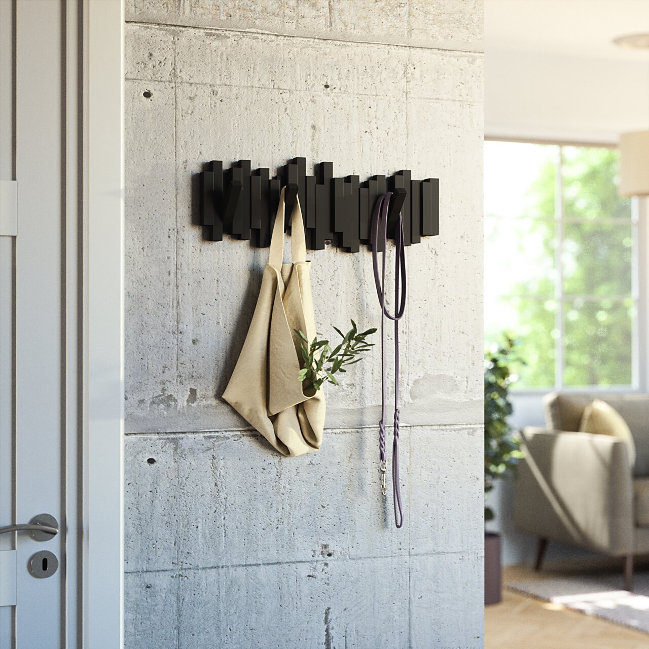 Moderne schwarze Wandgarderobe mit geometrischem Design, an der eine Tasche und ein Seil hängen. Perspektive von der Seite.