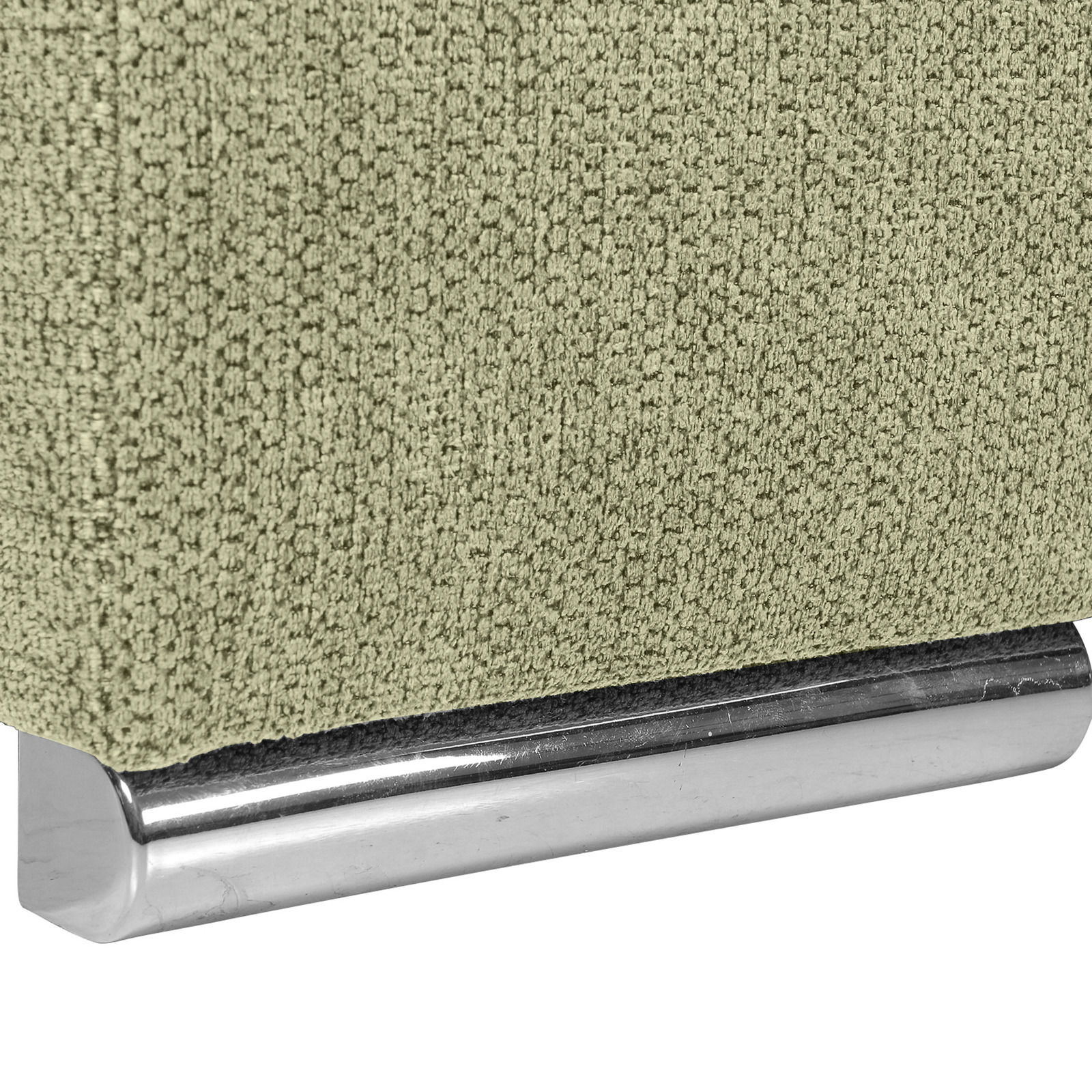 Nahaufnahme einer grünen, texturierten Stoffoberfläche mit einem glänzenden, metallischen Sockel. Perspektive von der Seite.