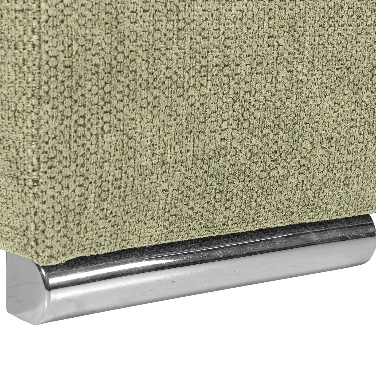 Nahaufnahme einer grünen, texturierten Stoffoberfläche mit einem glänzenden, metallischen Sockel. Perspektive von der Seite.