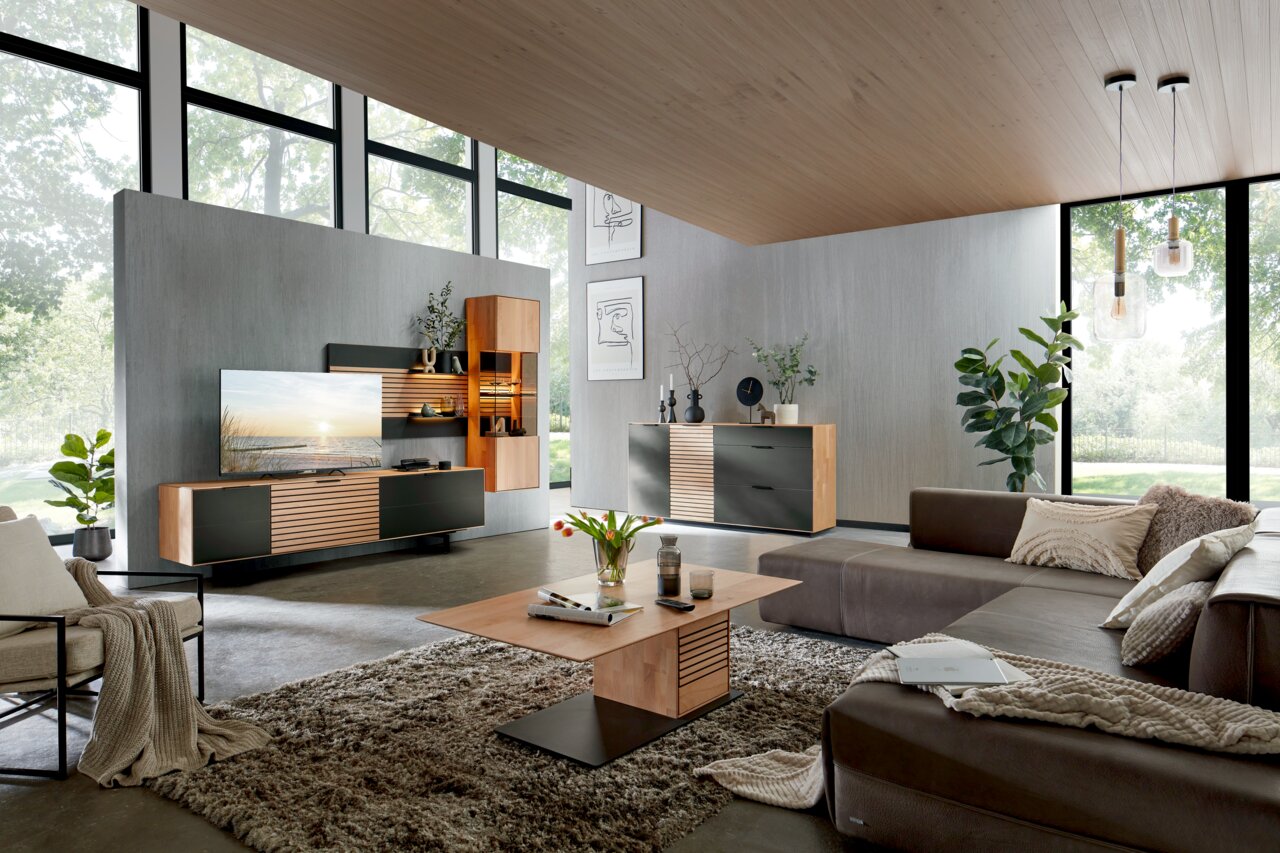 Moderne Wohnzimmermöbelkombination mit Wandregalen, Sideboard und Couchtisch in einer stilvollen, hellen Umgebung. Perspektive von schräg vorne.