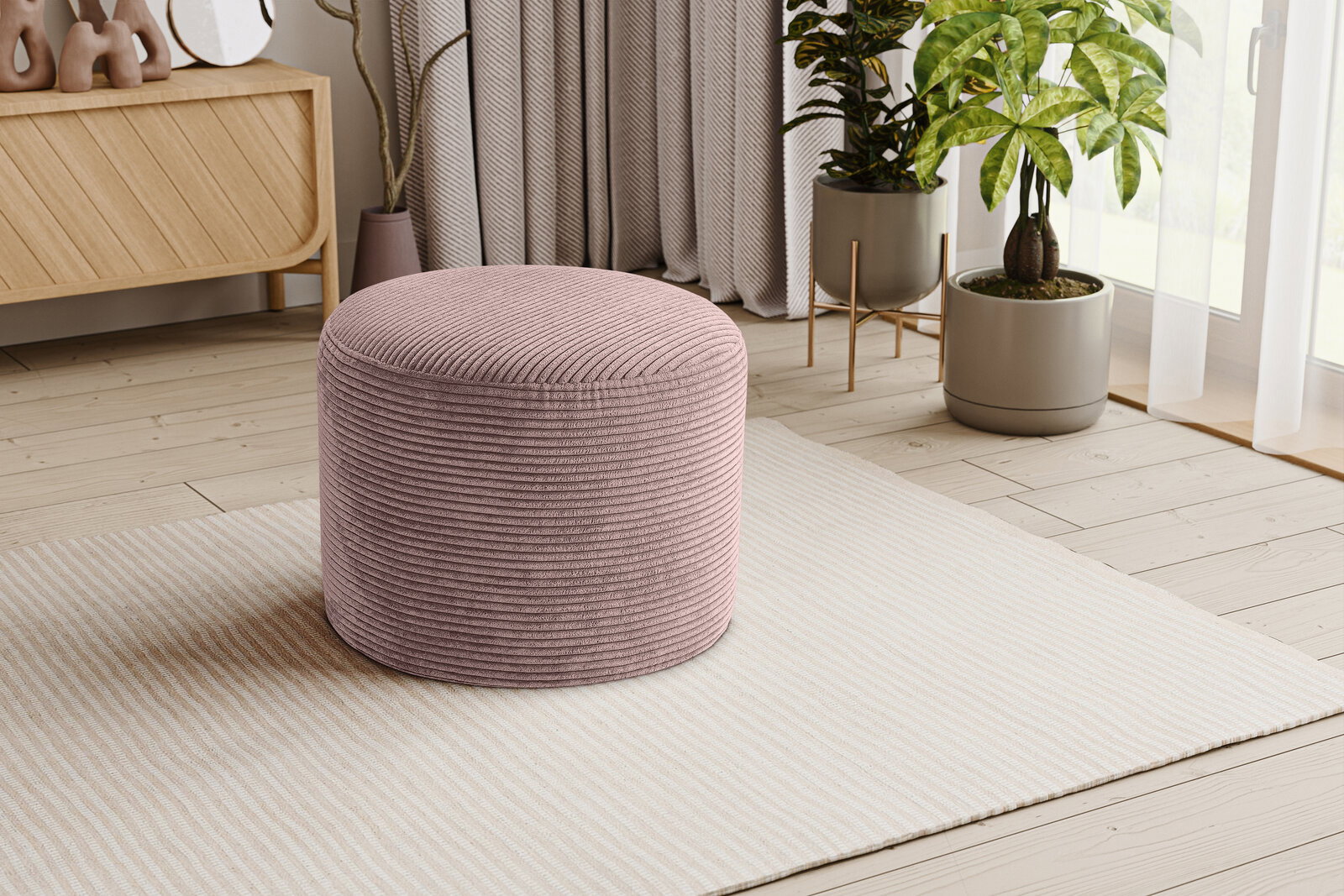 Runder, gerippter Pouf/Hocker in Altrosa auf hellem Teppich im Wohnzimmer, fotografiert in leichter Seitenansicht (3/4-Perspektive)