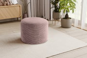Runder, gerippter Pouf/Hocker in Altrosa auf hellem Teppich im Wohnzimmer, fotografiert in leichter Seitenansicht (3/4-Perspektive)