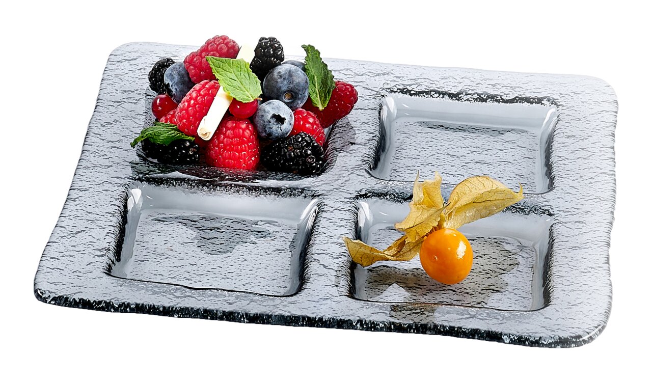 Rechteckige Servierschale aus Glas mit vier Fächern, gefüllt mit frischen Beeren und Physalis, aus der Vogelperspektive.