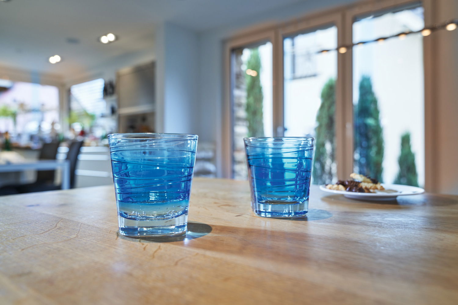 Leonardo Trinkglas VARIO Zwei blaue Trinkgläser Vario von Leonardo auf einem Holztisch in einem hellen Raum, seitliche Perspektive.