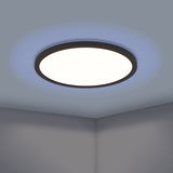 Runde LED-Deckenleuchte ROVITO-Z mit schwarzem Rahmen, von unten betrachtet, leuchtet mit einem blauen Lichtschein an der Decke.
