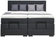 Frontale Ansicht eines modernen Boxspringbetts mit grauem Kopfteil und vier passenden Kissen.
