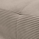 Nahaufnahme einer beigen, gerippten Stoffoberfläche eines Sofas, die eine Ecke zeigt.