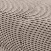 Nahaufnahme einer beigen, gerippten Stoffoberfläche eines Sofas, die eine Ecke zeigt.