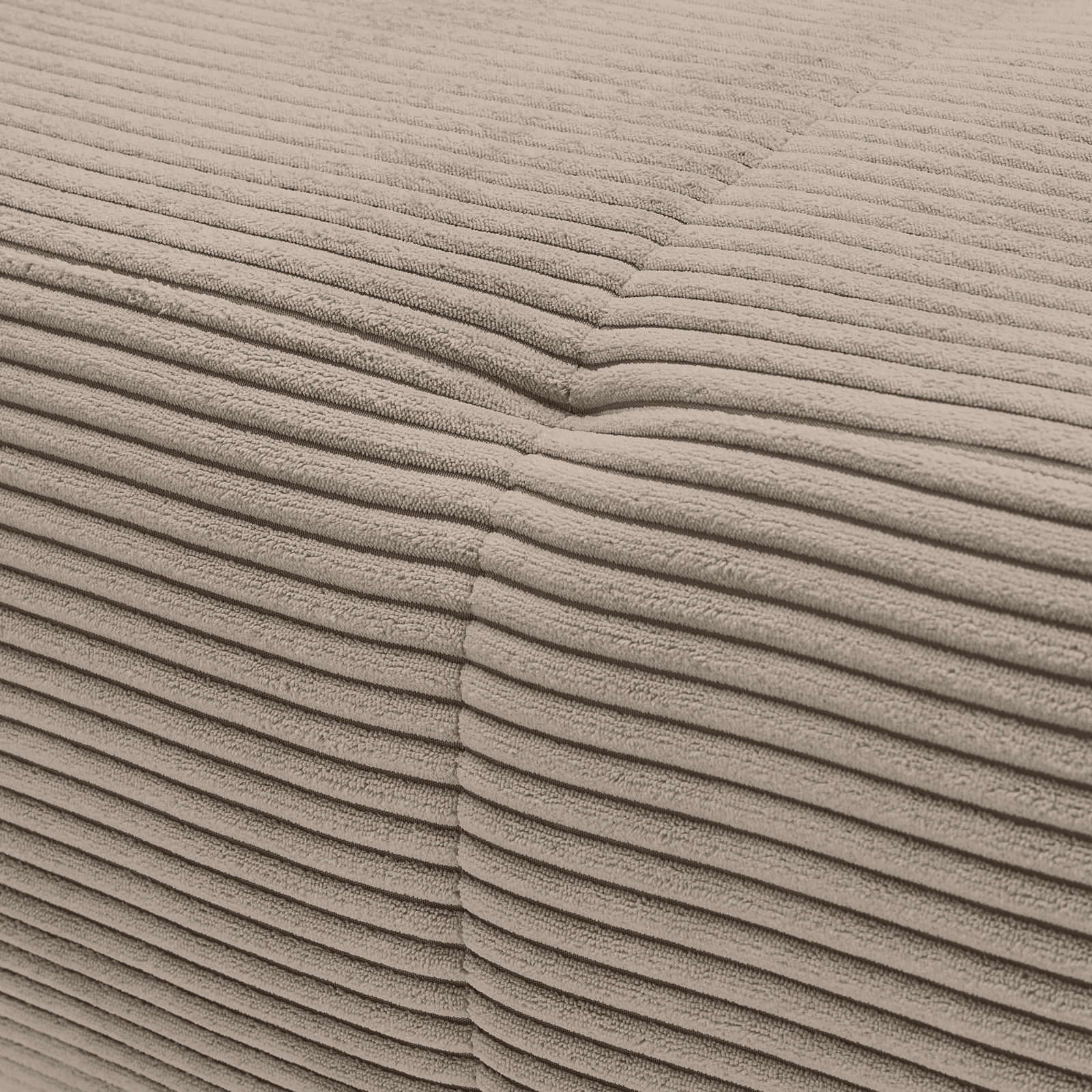 Nahaufnahme einer beigen, gerippten Stoffoberfläche eines Sofas, die eine Ecke zeigt.