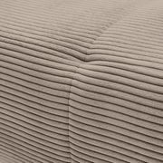 Nahaufnahme einer beigen, gerippten Stoffoberfläche eines Sofas, die eine Ecke zeigt.