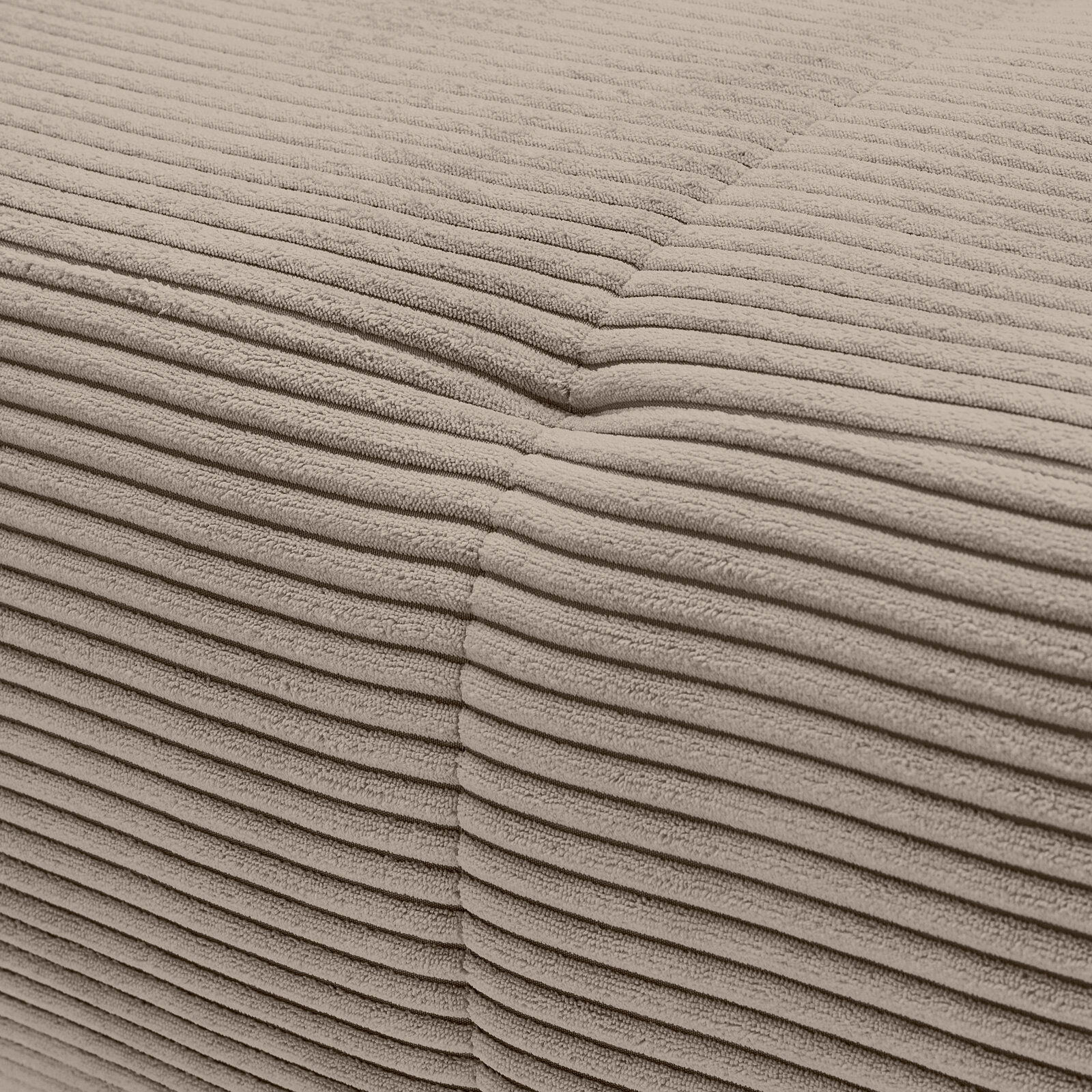 Nahaufnahme einer beigen, gerippten Stoffoberfläche eines Sofas, die eine Ecke zeigt.