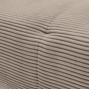 Nahaufnahme einer beigen, gerippten Stoffoberfläche eines Sofas, die eine Ecke zeigt.