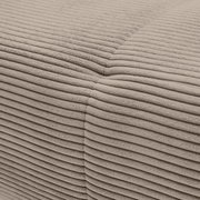 Close-up van het beige, geribbelde stoffen oppervlak van een bank, waarbij een hoek te zien is.
