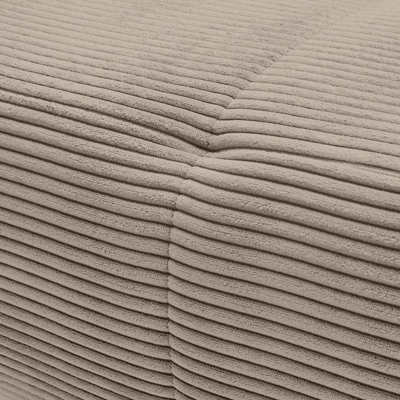 Close-up van het beige, geribbelde stoffen oppervlak van een bank, waarbij een hoek te zien is.
