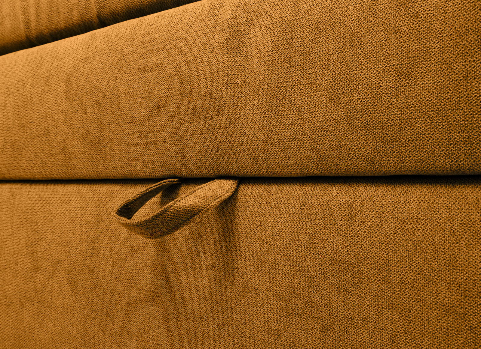 Nahaufnahme eines Boxspringbetts in braunem Stoff mit seitlichem Griff, seitliche Perspektive