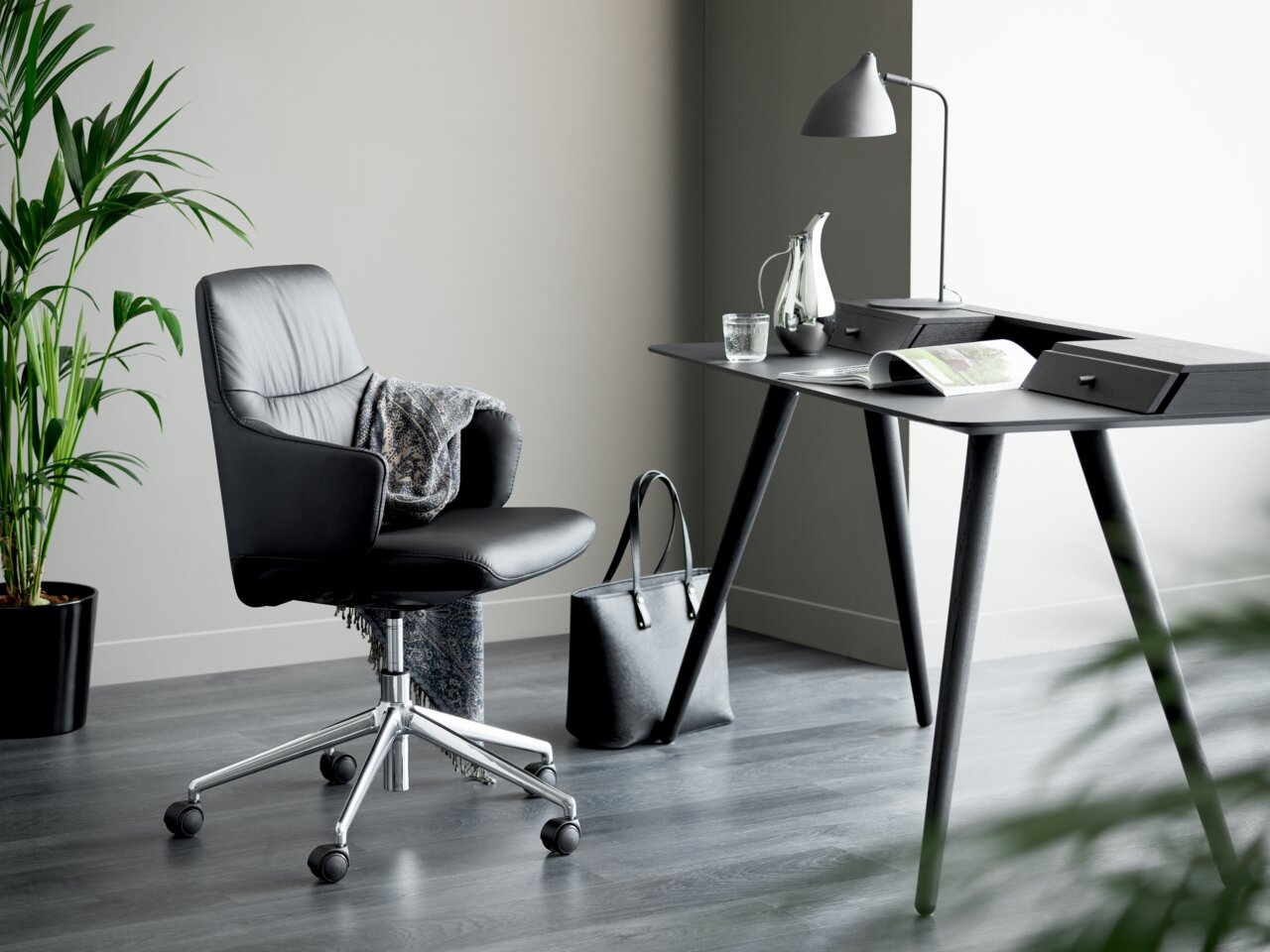 Moderner schwarzer Drehstuhl Stressless MINT in einem stilvollen Büro, seitliche Perspektive