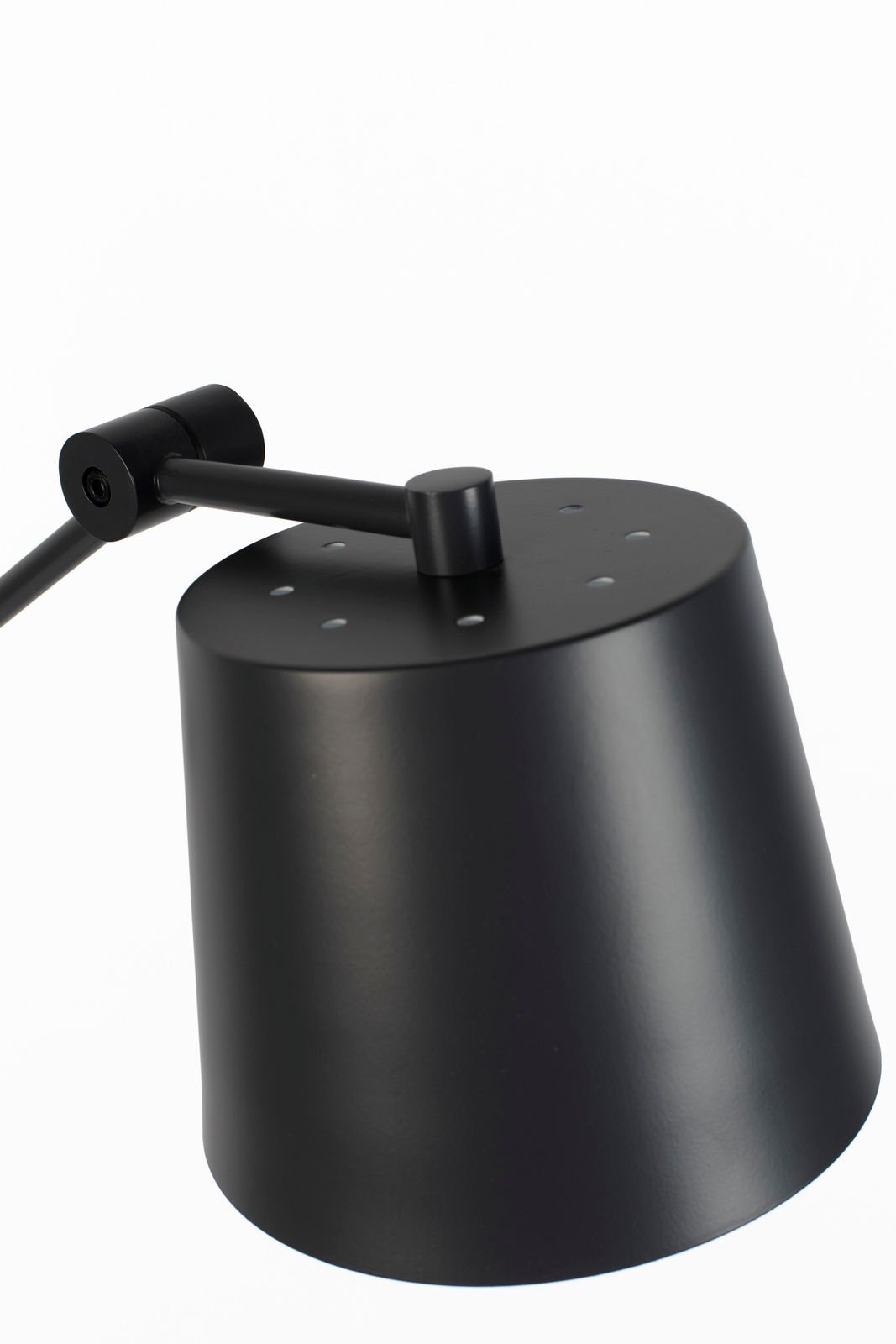 Nahaufnahme einer modernen schwarzen Stehleuchte mit zylindrischem Lampenschirm und verstellbarem Arm, seitliche Perspektive.