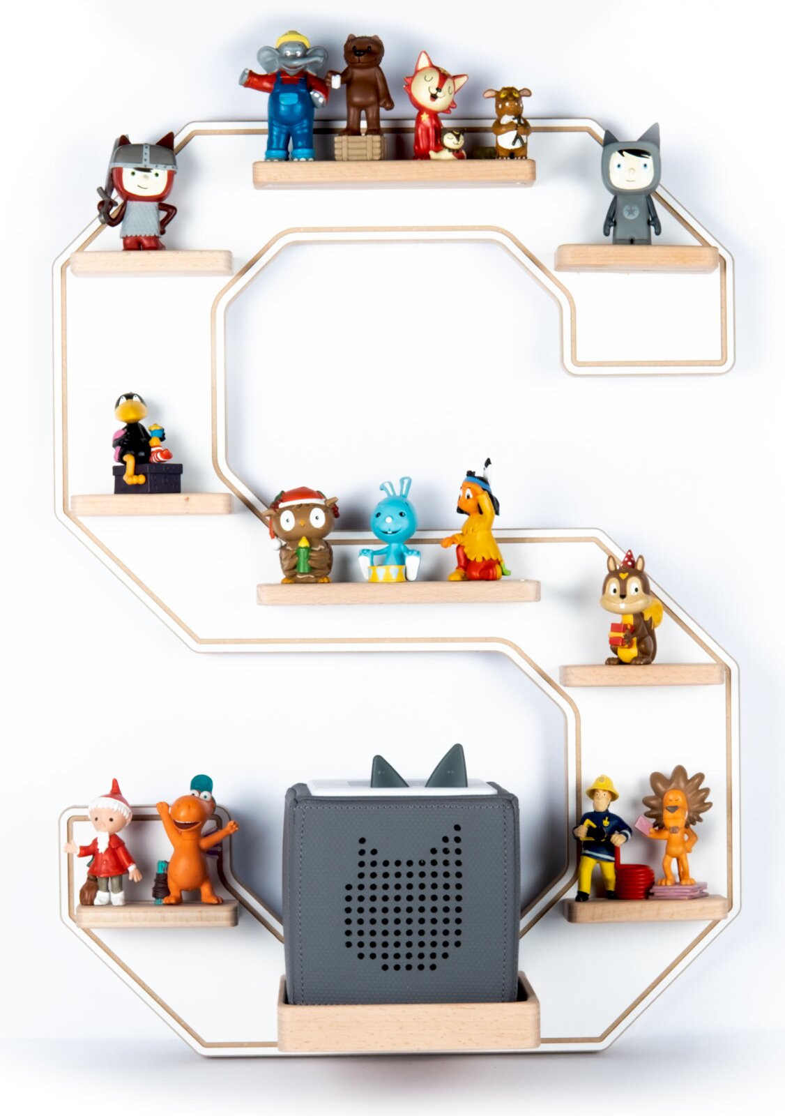 Frontalansicht eines dekorativen, wandmontierten Regals in Form eines großen Buchstabens mit mehreren kleinen Holzablagen, bestückt mit bunten Spielfiguren und einem grauen Lautsprecher in der Mitte vor weißem Hintergrund.