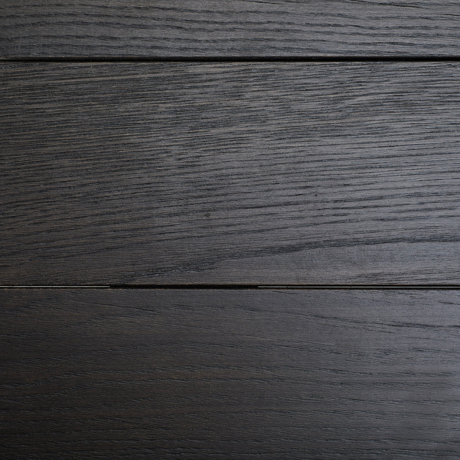 Draufsicht auf eine dunkle Holzoberfläche eines Esstisches mit sichtbarer Maserung.