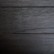 Draufsicht auf eine dunkle Holzoberfläche eines Esstisches mit sichtbarer Maserung.