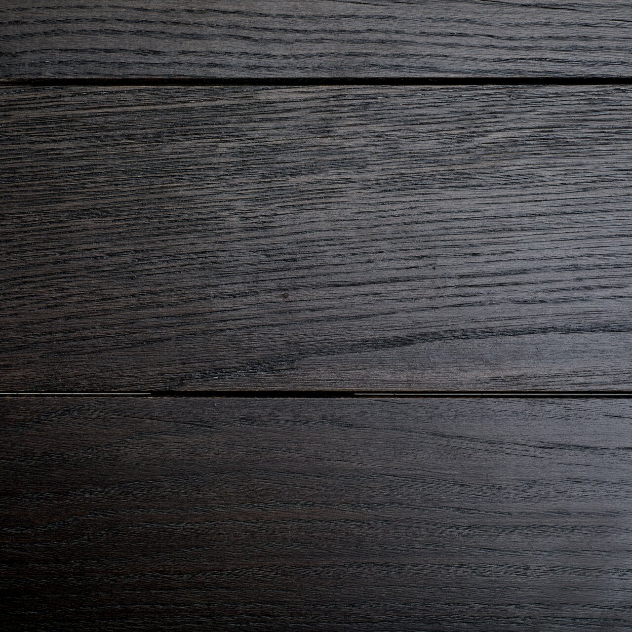 Draufsicht auf eine dunkle Holzoberfläche eines Esstisches mit sichtbarer Maserung.