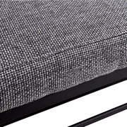 Nahaufnahme eines grauen, texturierten Stoffes auf einem Schuhregal mit schwarzem Metallrahmen, seitliche Perspektive