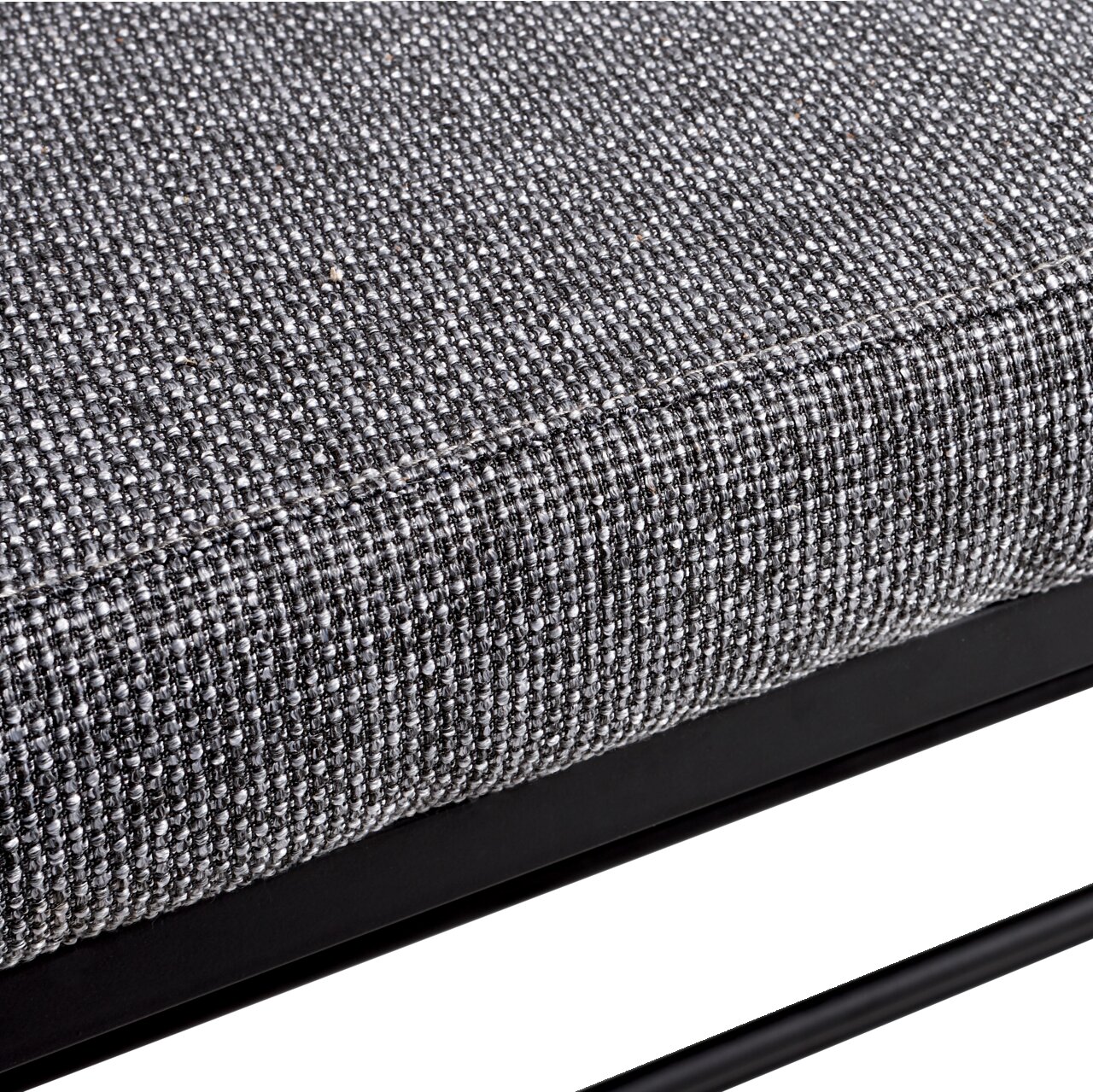 Nahaufnahme eines grauen, texturierten Stoffes auf einem Schuhregal mit schwarzem Metallrahmen, seitliche Perspektive