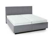 Grijs boxspringbed met hoog hoofdeinde en twee witte matrassen, zijaanzicht