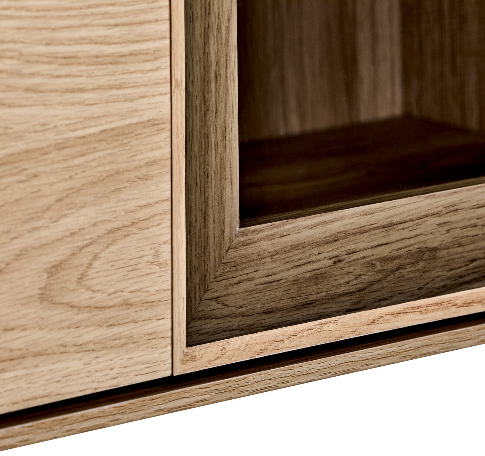 Detailaufnahme eines Möbelstücks in Holzoptik mit Glaseinsatz, Ansicht schräg von vorne auf die Ecke des Rahmens