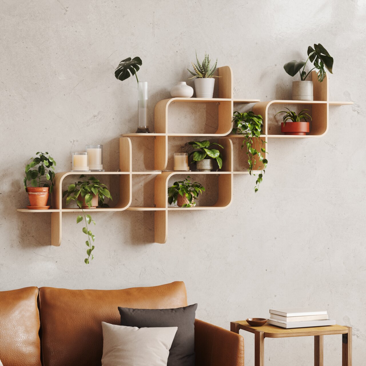 Modernes Wandregal aus Holz mit geschwungenem Design, dekoriert mit Pflanzen und Kerzen, an einer hellen Wand über einem Ledersofa montiert. Frontalansicht.
