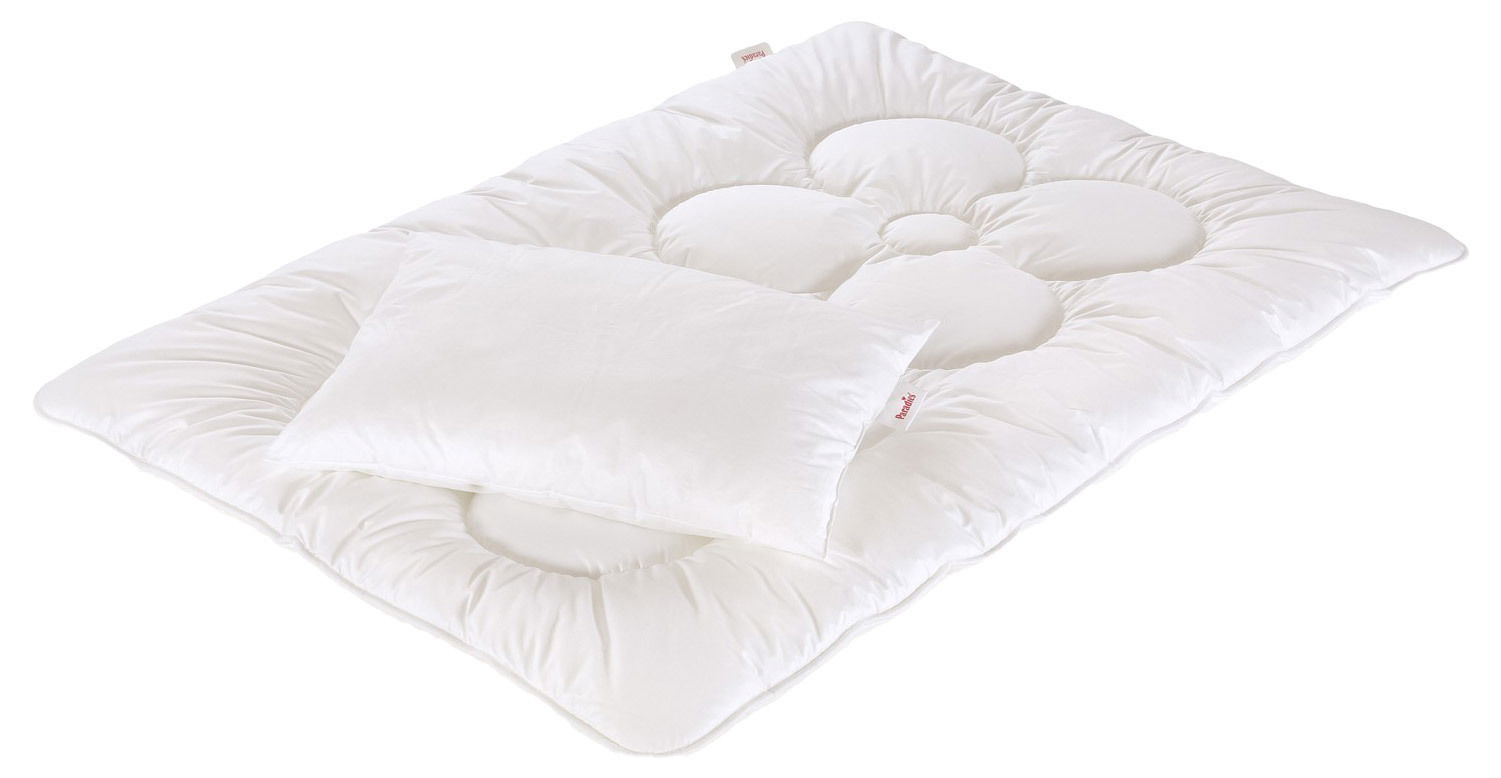 Paradies Kinder-Betten-Set ANELA BIO Weißes Kinder-Betten-Set bestehend aus einer gesteppten Decke und einem Kissen, aus der Vogelperspektive fotografiert.