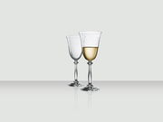 Zwei elegante Weingläser, eines gefüllt mit Weißwein, auf einer reflektierenden Oberfläche, seitliche Perspektive.