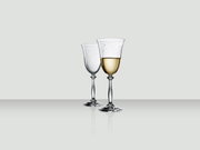 Twee elegante wijnglazen, waarvan één gevuld met witte wijn, op een spiegelend oppervlak, gezien vanuit de zijkant.