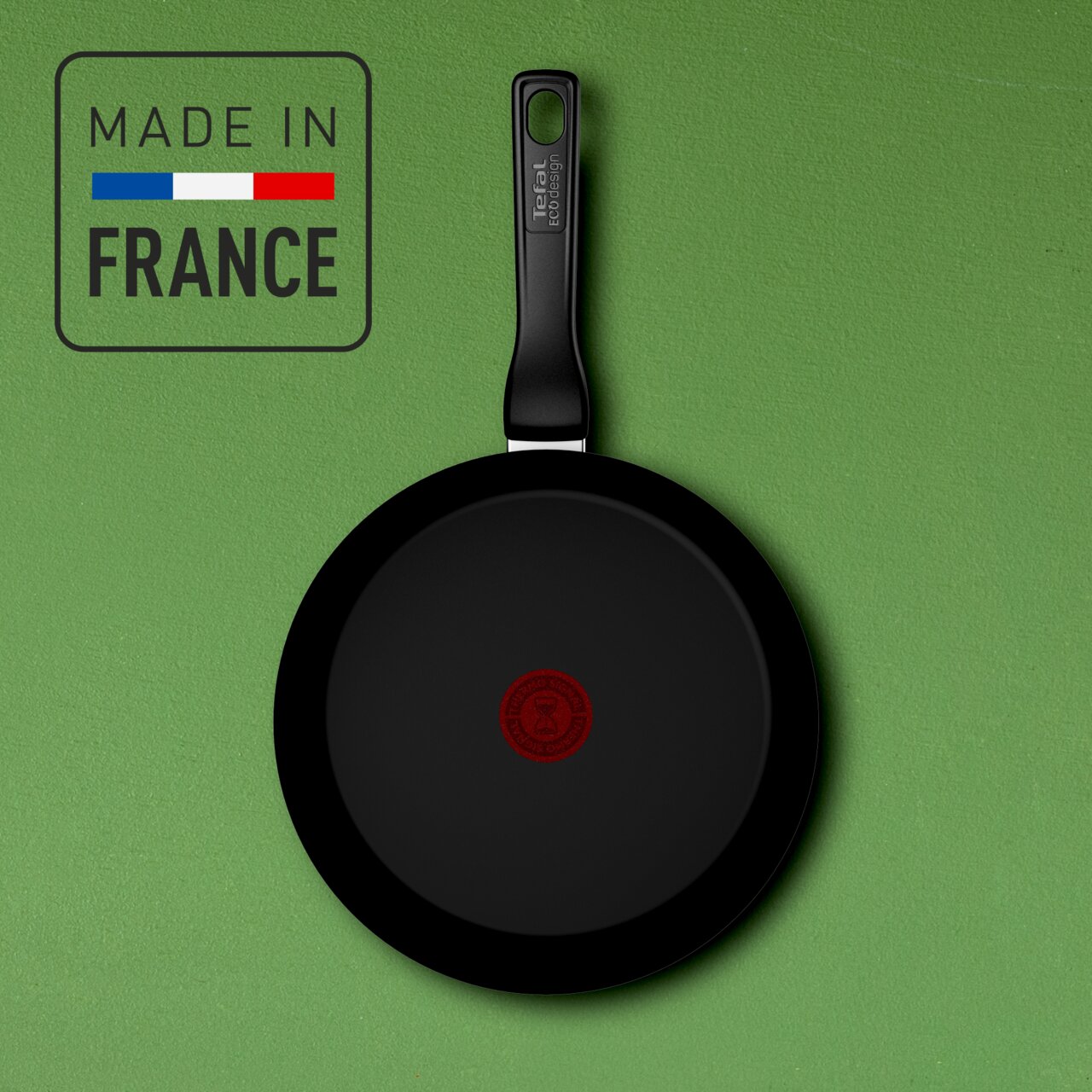 Keramik-Wokpfanne mit schwarzer Beschichtung und rotem Logo in der Mitte, Draufsicht, hergestellt in Frankreich.