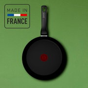 Keramik-Wokpfanne mit schwarzer Beschichtung und rotem Logo in der Mitte, Draufsicht, hergestellt in Frankreich.