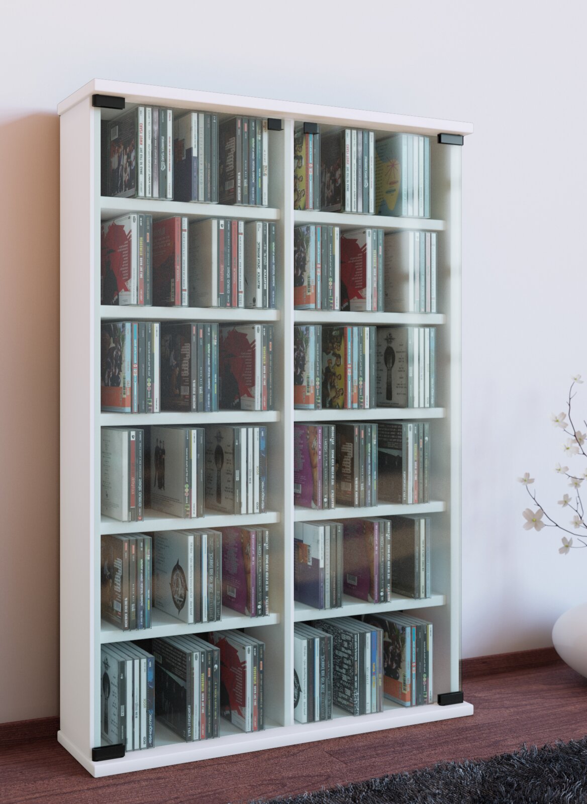 Weißes CD-/Medienregal mit mehreren Fächern und transparenten Fronten, gefüllt mit CDs, freistehend an einer Wand; Perspektive: frontale Ansicht leicht von links.