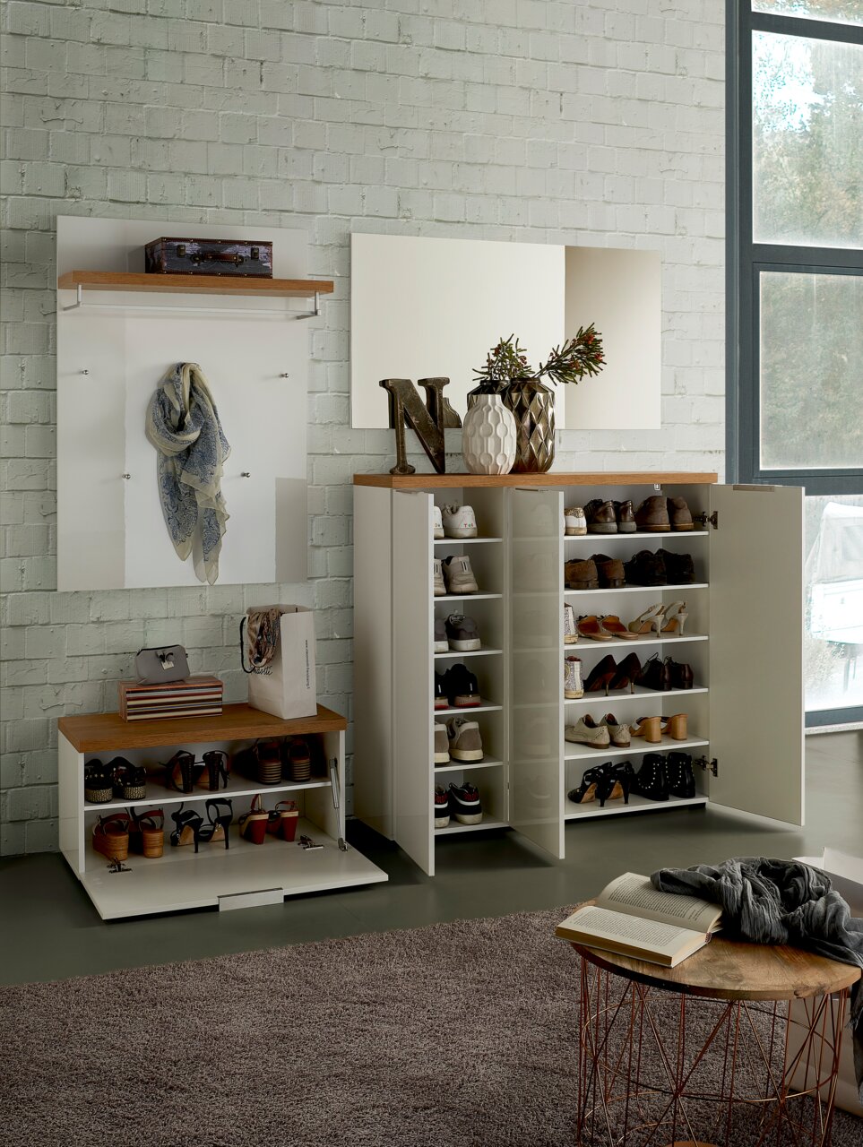 Moderne Garderobeneinrichtung mit Schuhschrank, Garderobenpaneel und Spiegel in einer hellen, stilvollen Umgebung. Frontalansicht.