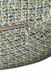 Nahaufnahme einer Zierkissenhülle mit grobem, mehrfarbigem Gewebe und einem Reißverschluss mit dem Schriftzug 'JOOP!'