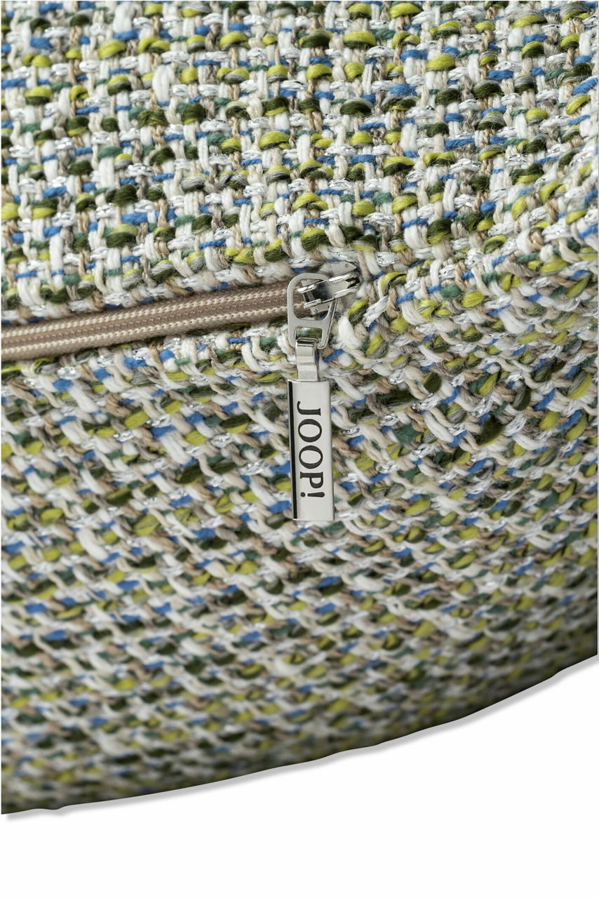 Nahaufnahme einer Zierkissenhülle mit grobem, mehrfarbigem Gewebe und einem Reißverschluss mit dem Schriftzug 'JOOP!'