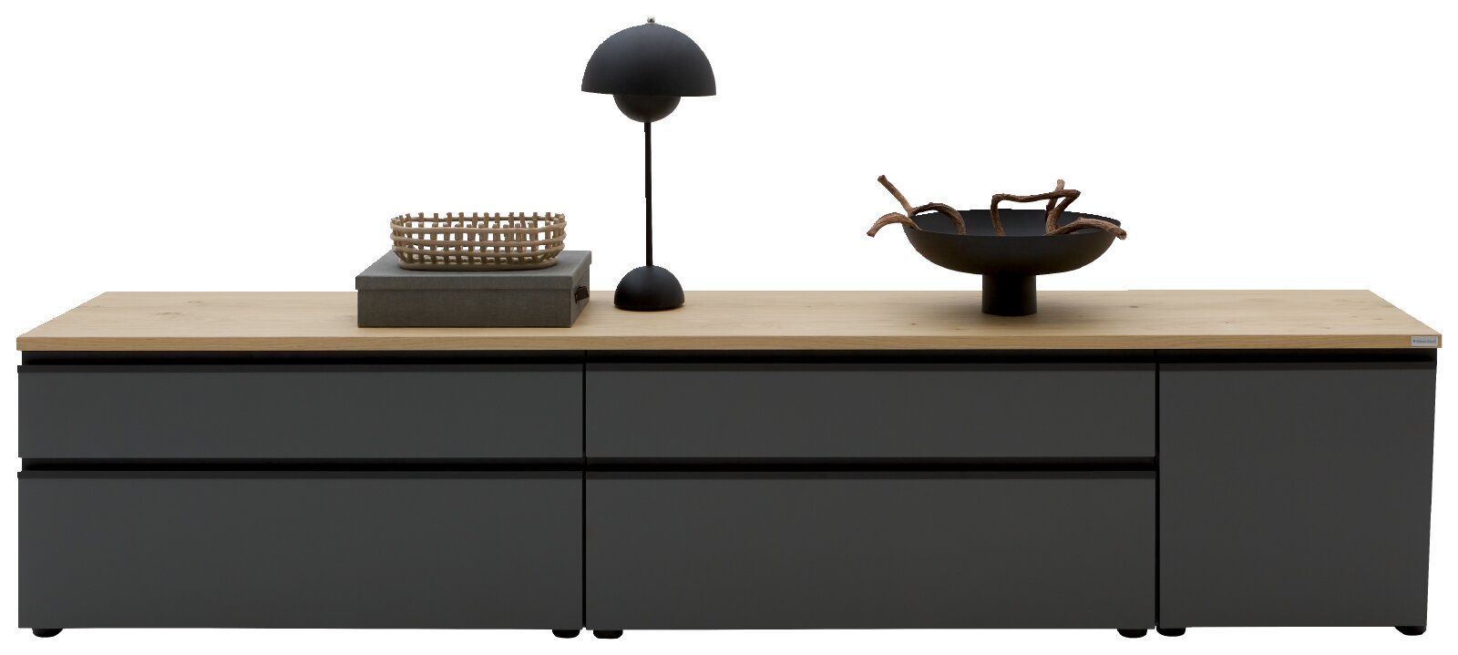 Moderne, niedrige Kommode/Sideboard in Anthrazit mit Holzplatte, frontal aus leichter Augenhöhe fotografiert; oben dekoriert mit schwarzer Tischlampe, Korb und Schale.