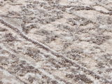 Nahaufnahme eines Designer-Teppichs mit weicher, flauschiger Textur in creme- und grautönen, diagonale Perspektive.