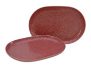 Zwei ovale, rotbraune Keramik-Servierplatten mit geprägtem Mandala-Ornament, in schräger Vorderansicht (eine liegend, eine dahinter aufrecht)