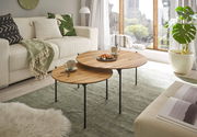Moderner Couchtisch aus Holz mit schwarzem Metallgestell, bestehend aus zwei runden Tischen in unterschiedlicher Höhe, in einem gemütlichen Wohnzimmer mit Blick aus dem Fenster.