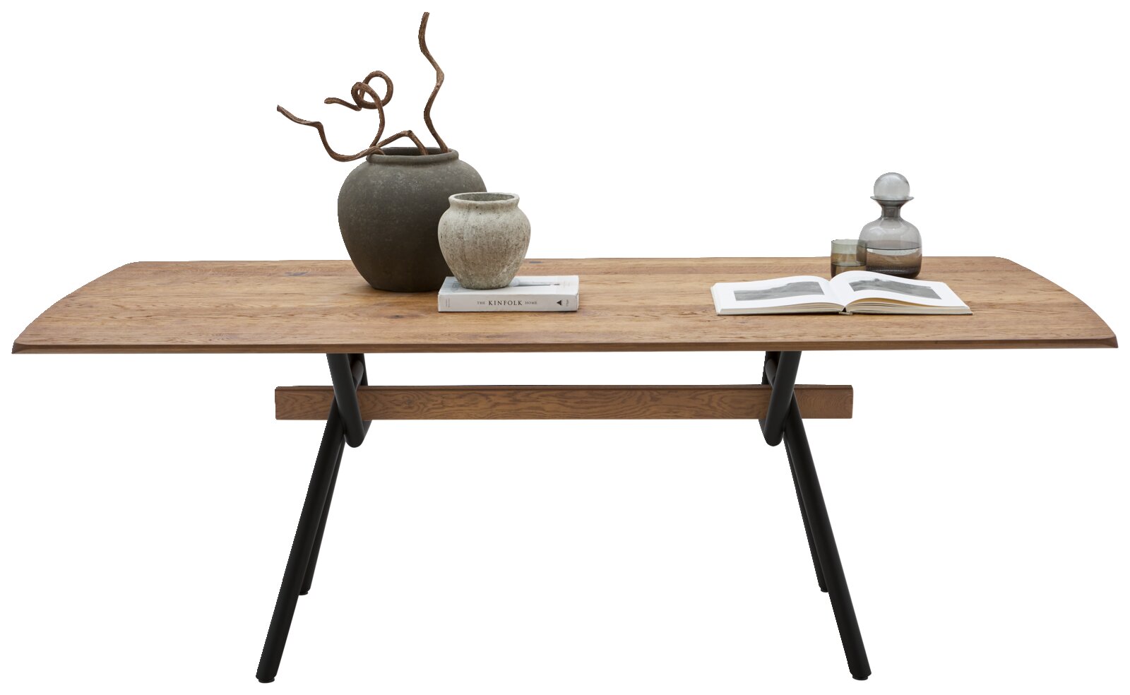 Rechthoekige houten eettafel met afgeronde hoeken en zwarte metalen poten, frontaal zijaanzicht op witte achtergrond, gestyled met vazen, boek en karaf.