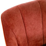 Nahaufnahme eines roten Armlehnstuhls mit strukturiertem Stoffbezug, Ansicht von oben.