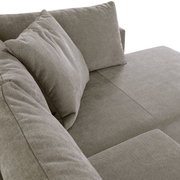 Nahaufnahme eines Ecksofas SORIA in grauem Stoff, Perspektive von oben auf die Sitzfläche und Kissen.