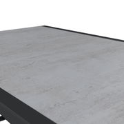 Nahaufnahme eines modernen Gartentisches mit grauer Steinoptik-Oberfläche, perspektivisch von oben betrachtet.