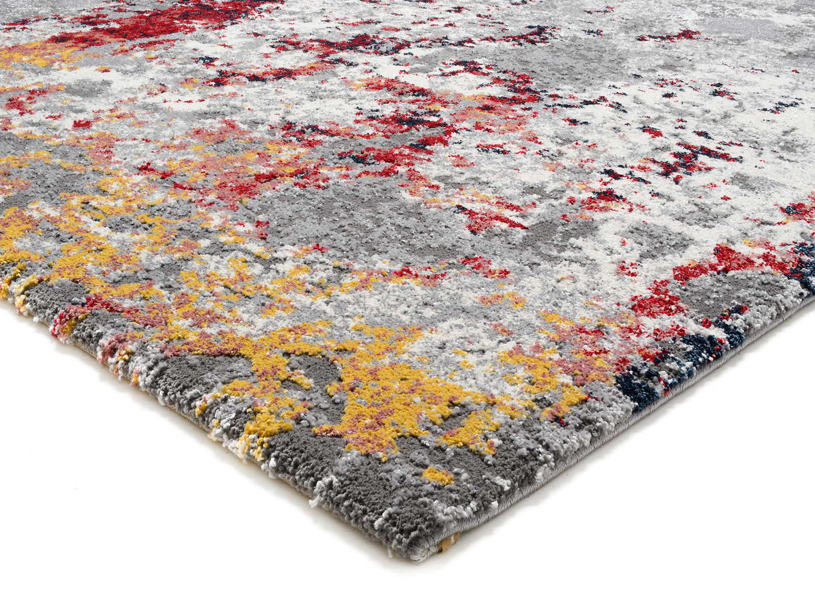 Designer Teppich mit abstraktem Muster in Grau, Rot und Gelb, perspektivisch von der Seite fotografiert