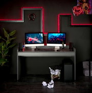 Modern bureau in een stijlvolle gamingopstelling met twee beeldschermen, toetsenbord en muis, omringd door ledverlichting en decoraties, gezien vanuit een vooraanzicht.