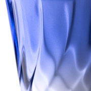 Nahaufnahme eines blauen Trinkglases mit gedrehtem Design, seitliche Perspektive